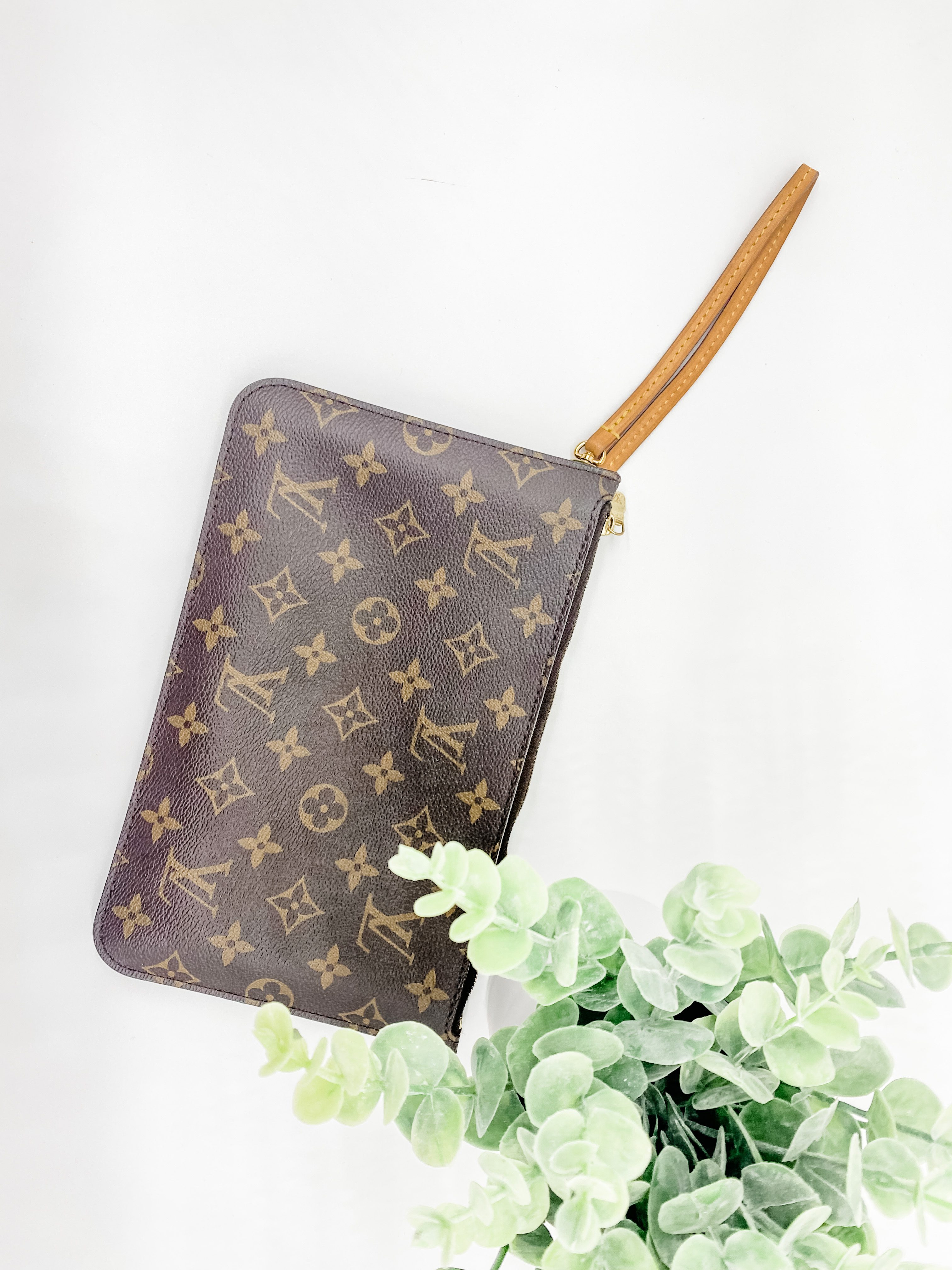 The bag includes a zippered wristlet that can be used for a variety of purposes.